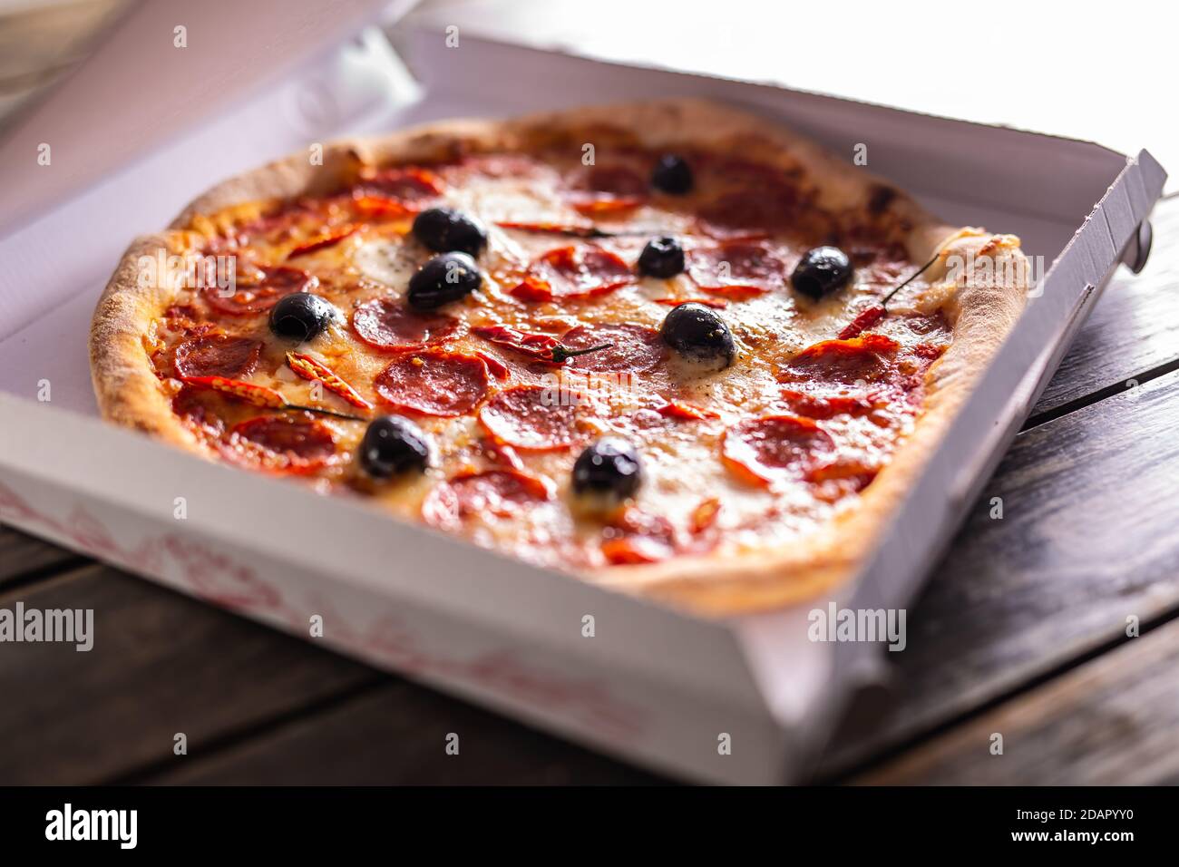 Pizza dans une boîte en carton sur la table, prête pour le client. Banque D'Images
