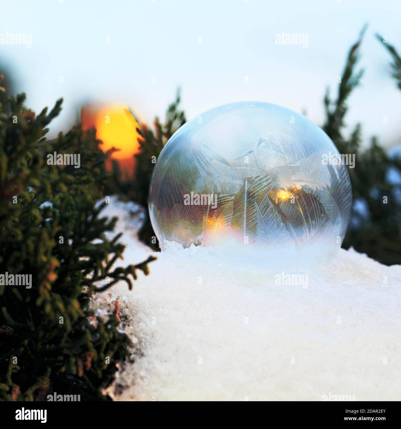 La bulle de savon gelée dans la neige forme des cristaux de glace, le soleil couchant se reflète dans elle, Rhénanie-du-Nord-Westphalie, Allemagne Banque D'Images