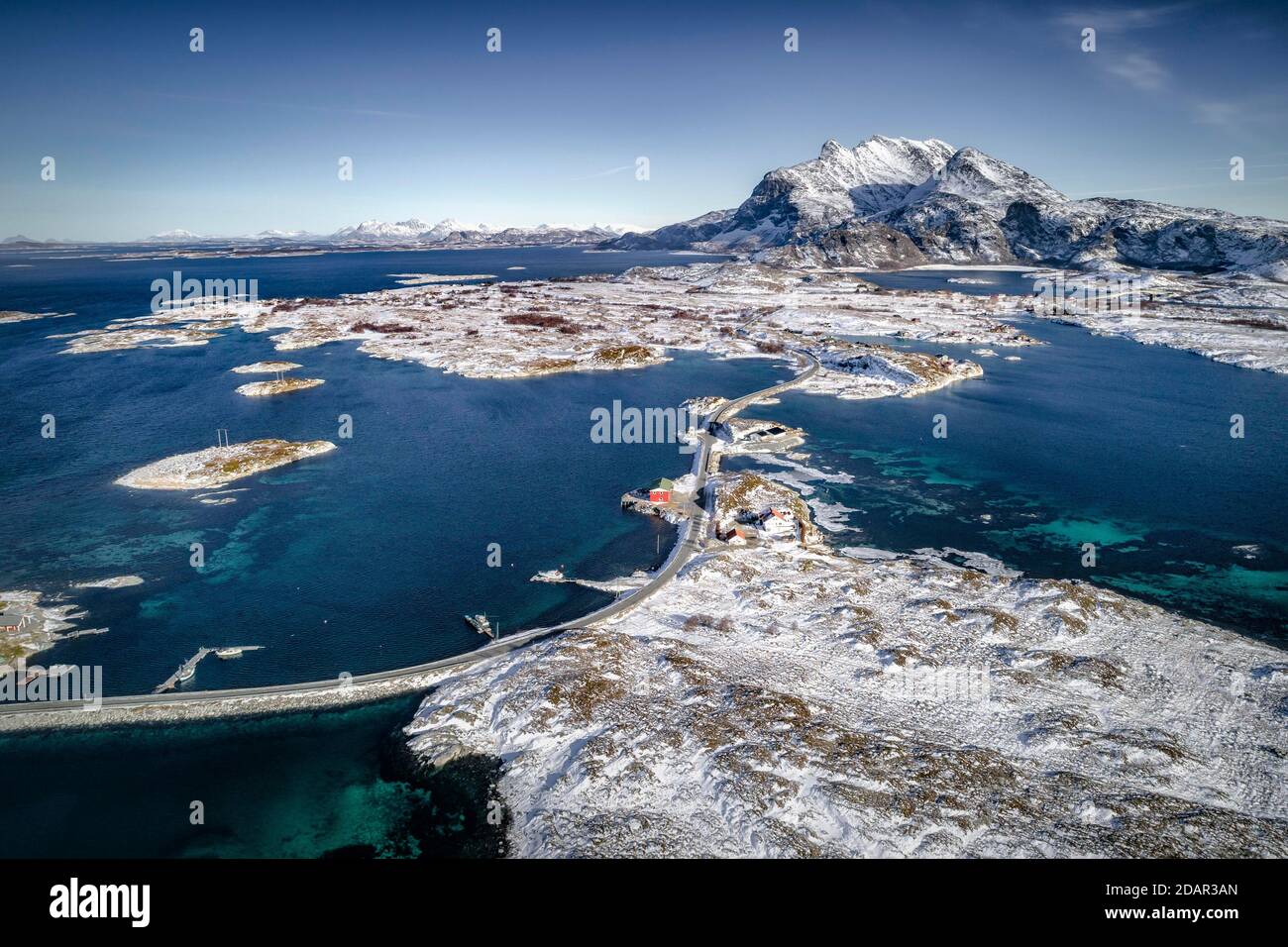 Vue aérienne, route de campagne à travers la mer relie les îles peuplées, petites, hivernales avec le continent, derrière les montagnes, Heroy, Nordland, Norvège Banque D'Images