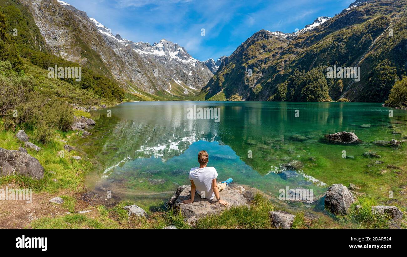 Randonneur assis sur la rive, lac Marian, parc national Fiordland, te Anau, Southland, Île du Sud, Nouvelle-Zélande Banque D'Images