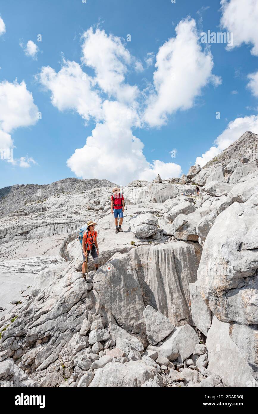 Deux randonneurs dans un paysage de roches karstiques délavées, Funtenseetauern, Steinernes Meer, Parc national de Berchtesgaden, Berchtesgadener Land, Upper Banque D'Images