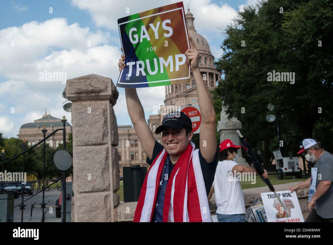 Austin, TX USA 14 novembre 2020 : drapé dans un drapeau américain, un jeune homme portant un panneau « Gays for Trump » rejoint plusieurs centaines de partisans du Prest. Donald Trump lors d'un rassemblement au Capitole du Texas. Les manifestants sont catégoriques sur le fait que le président ne doit pas concéder à Joe Biden tant que les cas de fraude électorale ne sont pas examinés et que tous les votes ne sont pas comptés. Jusqu'à présent, aucun cas généralisé de vote illégal n'a surgi près de deux semaines après les élections. Crédit : Bob Daemmrich/Alay Live News Banque D'Images