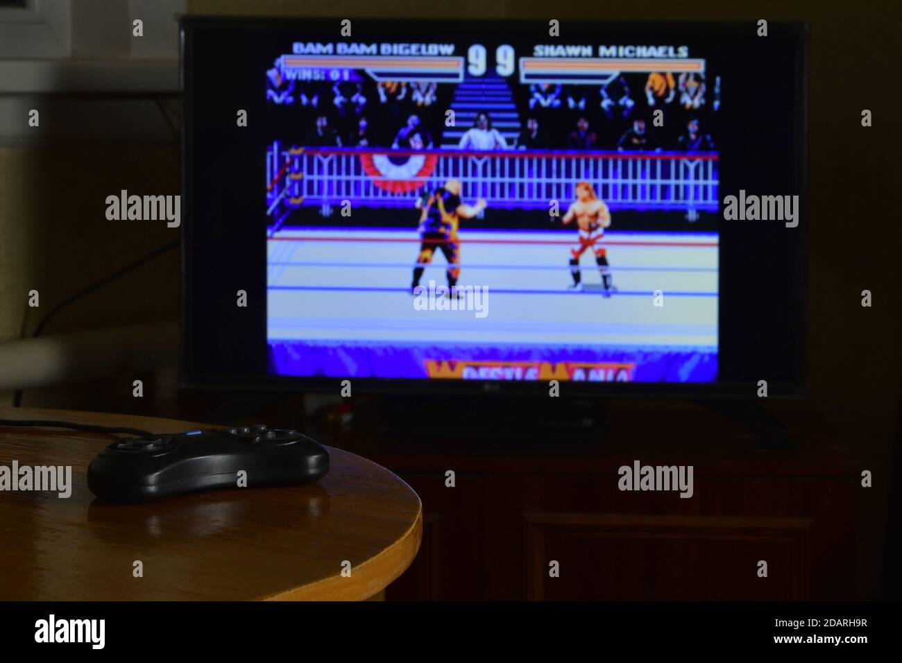 KHARKOV, UKRAINE - NOVEMBRE 12, 2020: Sega méga drive contrôleur de jeu vidéo sur table avec Wrestlemania jeu sur grand écran Banque D'Images