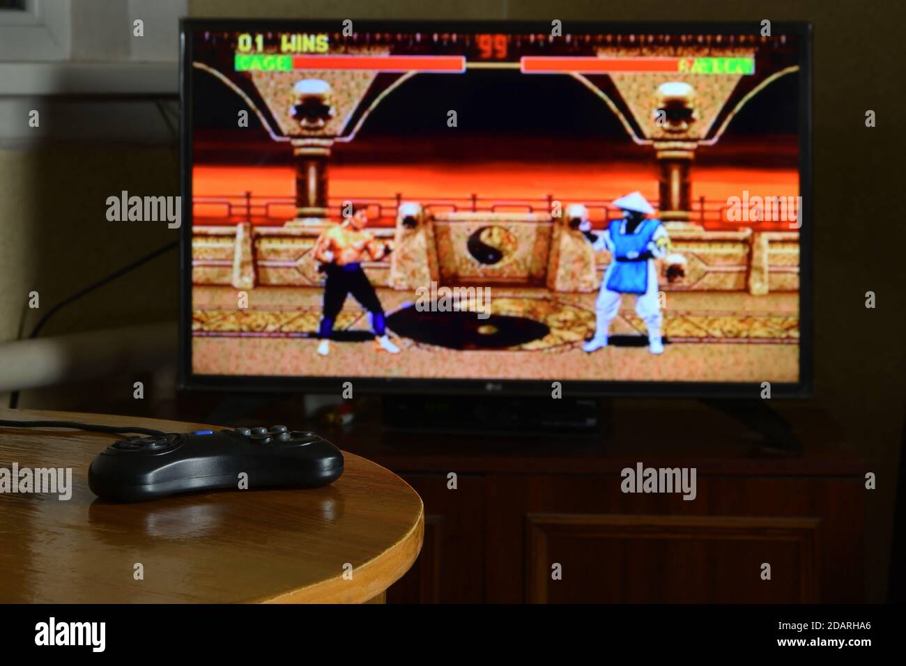 KHARKOV, UKRAINE - NOVEMBRE 12, 2020: Sega méga drive contrôleur de jeu vidéo sur table avec Mortal Kombat 2 jeu sur grand écran Banque D'Images