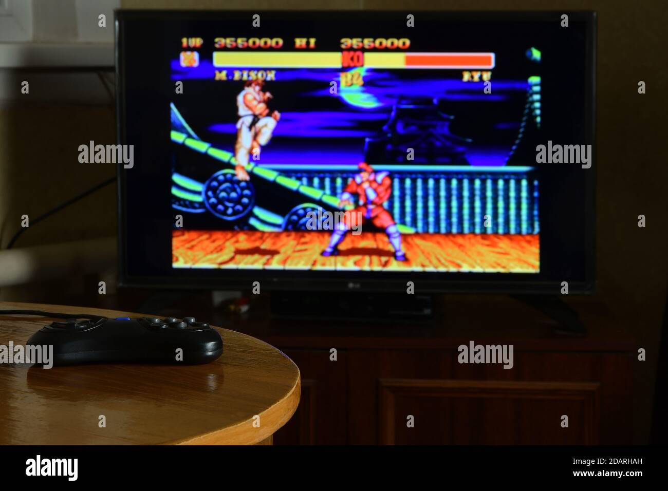 KHARKOV, UKRAINE - NOVEMBRE 12, 2020: Sega méga Drive contrôleur de jeu vidéo sur table avec Street Fighter 2 jeu sur grand écran Banque D'Images