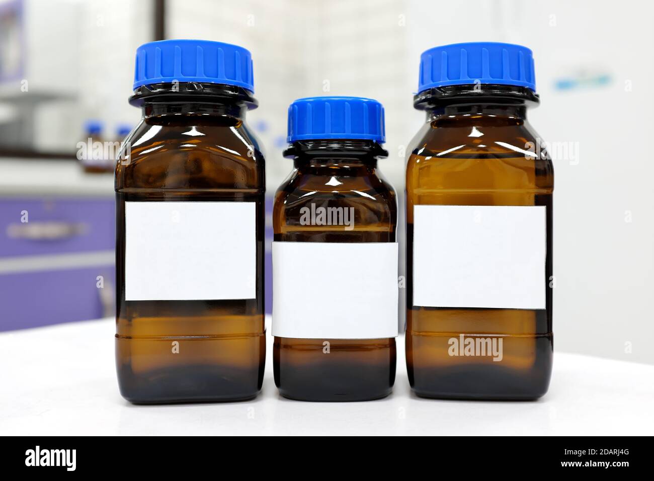 Foyer slectif de trois flacons de ractif en verre fonc avec un produit  chimique liquide clair inconnu  l'intrieur et une tiquette vierge dans  un laboratoire de chimie Photo Stock - Alamy