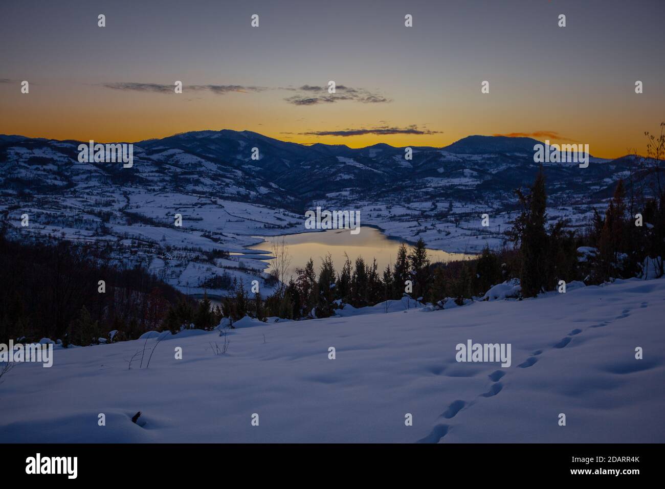 Coucher de soleil coloré au lac de montagne Rovni dans la neige, belle nature scène d'hiver en Serbie Banque D'Images