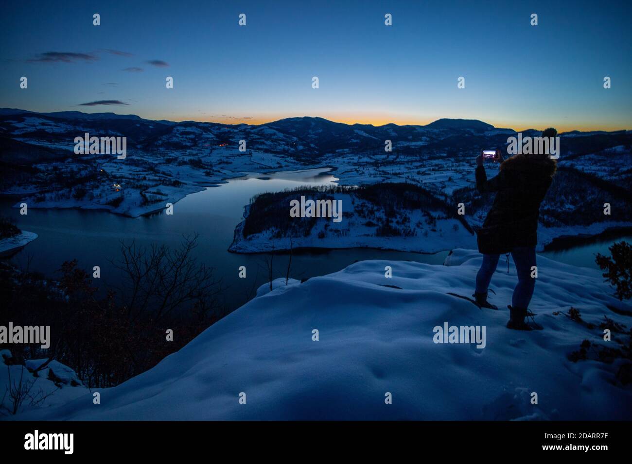 Photographes photographiant la scène d'hiver de montagne de lac au coucher du soleil, seul dans la nature. Rovni, Valjevo, Serbie Banque D'Images