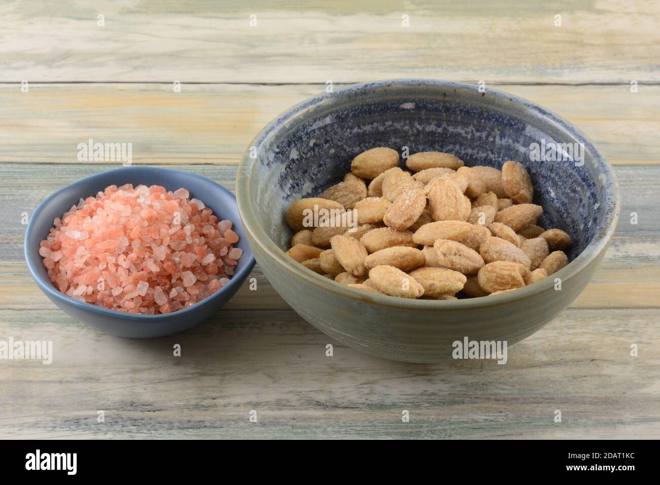 Sel rose himalayan et amandes entières salées avec du rose himalayan sel dans les bols sur la table Banque D'Images