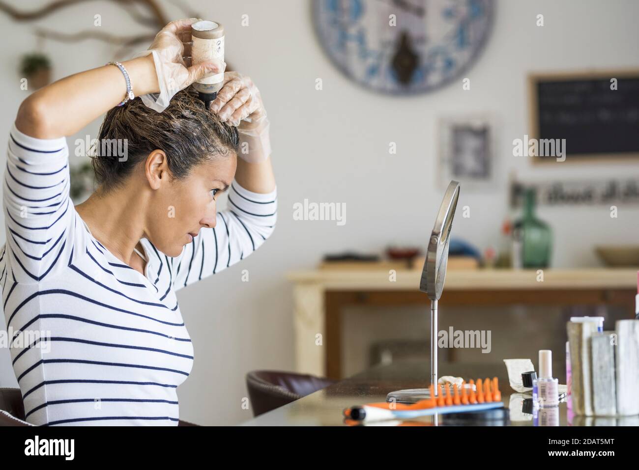 Jeune belle femme colorant ses cheveux à la maison elle-même avec produits chimiques - traitement pour le vieillissement des cheveux blancs et laqués adulte femelle caucasien peo Banque D'Images