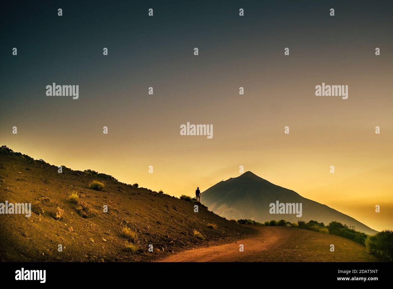 Homme debout avec vue sur les montagnes et coucher de soleil ciel coloré - concept de voyage d'aventure et parc extérieur activité de loisirs pour peopl Banque D'Images