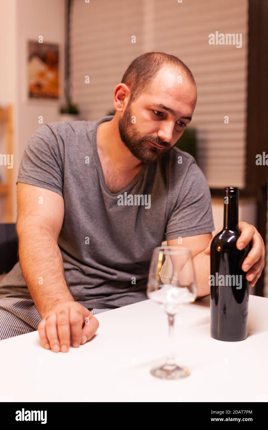 Homme tenant une bouteille de vin rouge étant déçu à cause de l'épouse  infidèle. Personne malheureuse maladie et anxiété sensation d'épuisement  avec étourdissements symptômes ayant des problèmes d'alcoolisme Photo Stock  - Alamy