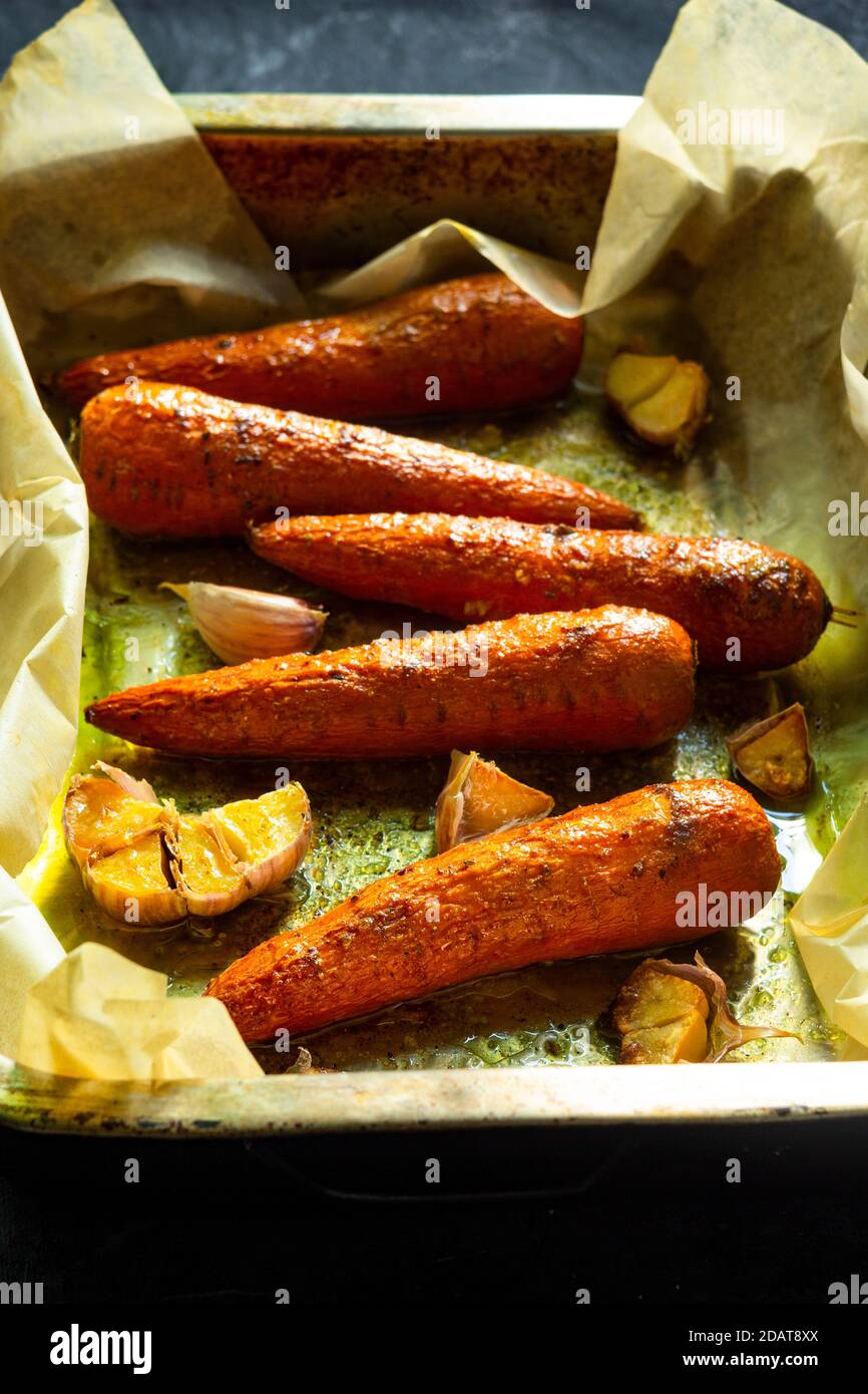 Des carottes cuites à l'ail sur des brochettes du four. Banque D'Images