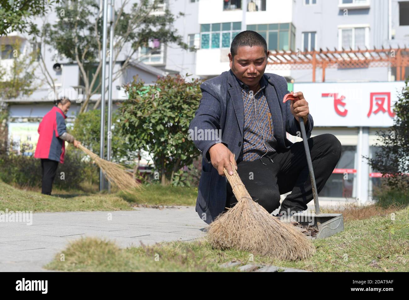 (201115) -- YUPING, le 15 novembre 2020 (Xinhua) -- Yao Maozhong (R), un villageois déplacé, nettoie les feuilles mortes dans la communauté de réinstallation où certains des villageois déplacés du village de Tiejiaxi vivent dans le comté autonome de Yuping Dong, dans la province de Guizhou, dans le sud-ouest de la Chine, le 14 novembre 2020. Le village de Tiejiaxi était l'un des 14 villages en proie à la pauvreté dans le comté. Depuis 2014, le gouvernement local a fait de grands efforts pour aider les villageois à se débarrasser de la pauvreté. D'une part, le gouvernement local a amélioré l'infrastructure et a essayé de conduire les villageois à s'engager dans l'industrie éco-agricole, Banque D'Images