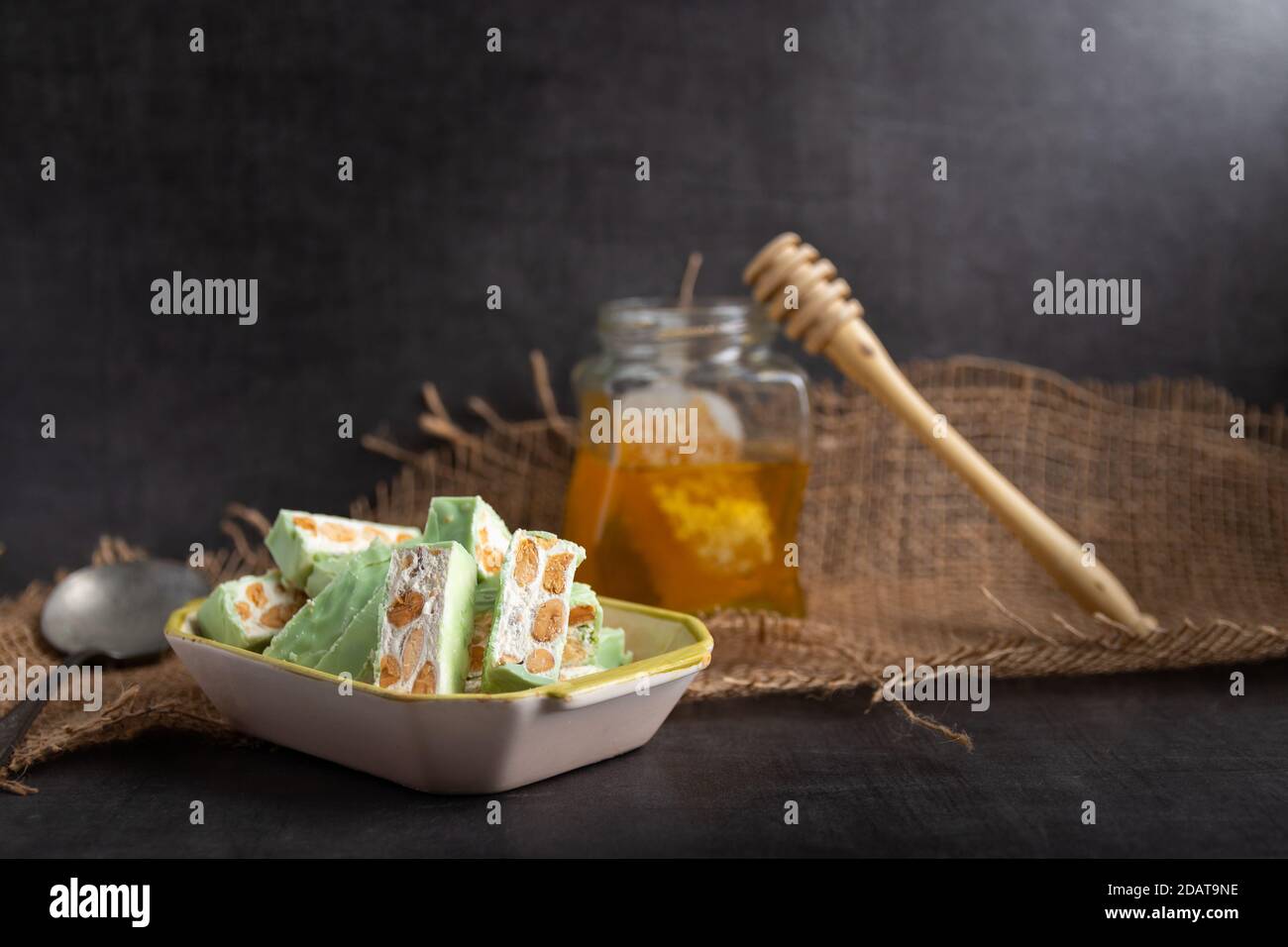 Nougat bio faites avec du miel, pistache, noisette, noix et amandes, sur un fond sombre. rustique Banque D'Images