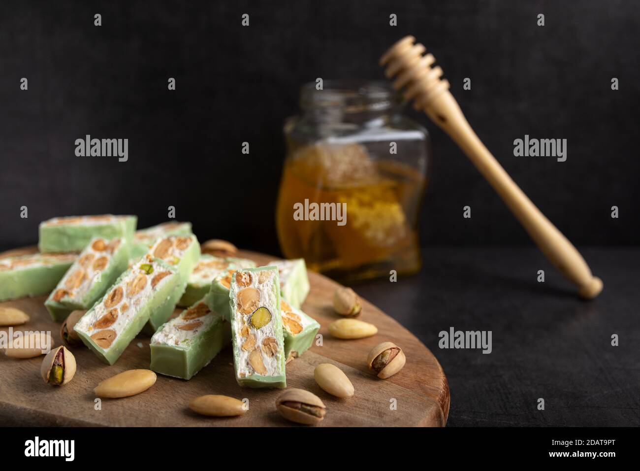 Nougat bio faites avec du miel, pistache, noisette, noix et amandes, sur un fond sombre. rustique Banque D'Images
