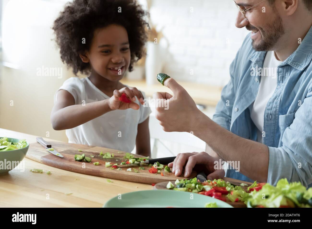 Gros plan père et fille afro-américaine jouant avec des légumes Banque D'Images