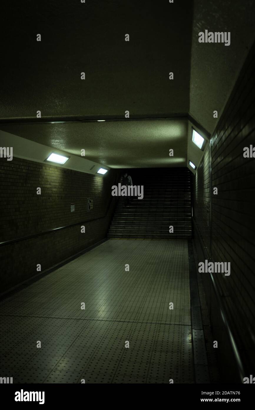 Personne escaladant les escaliers dans un métro semi-sombre et créepy tunnel de la station Banque D'Images