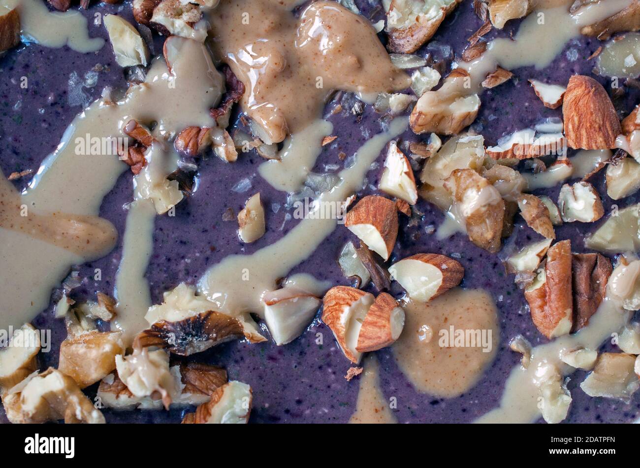 Un bol à smoothie aux baies recouvert de noix et de tahini Banque D'Images