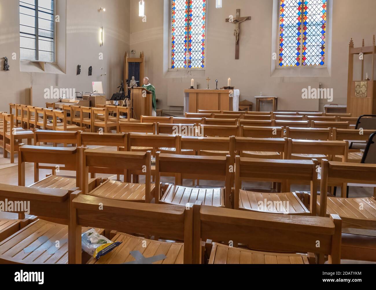 Un prêtre prêche à une église vide pendant le confinement, la congrégation suit Zoom et Facebook Banque D'Images