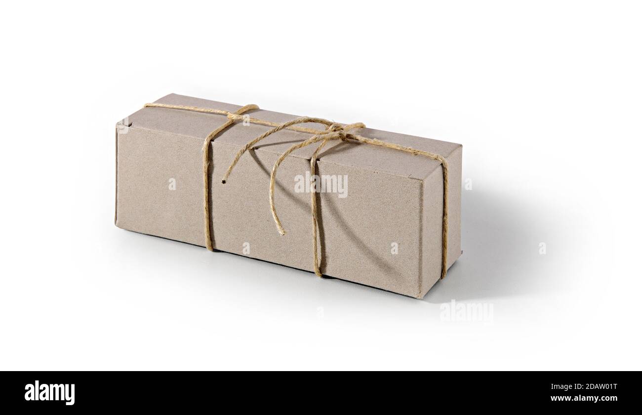 Boîte en carton recyclé neutre, fermée par une ficelle, sur fond blanc, avec des ombres. Banque D'Images