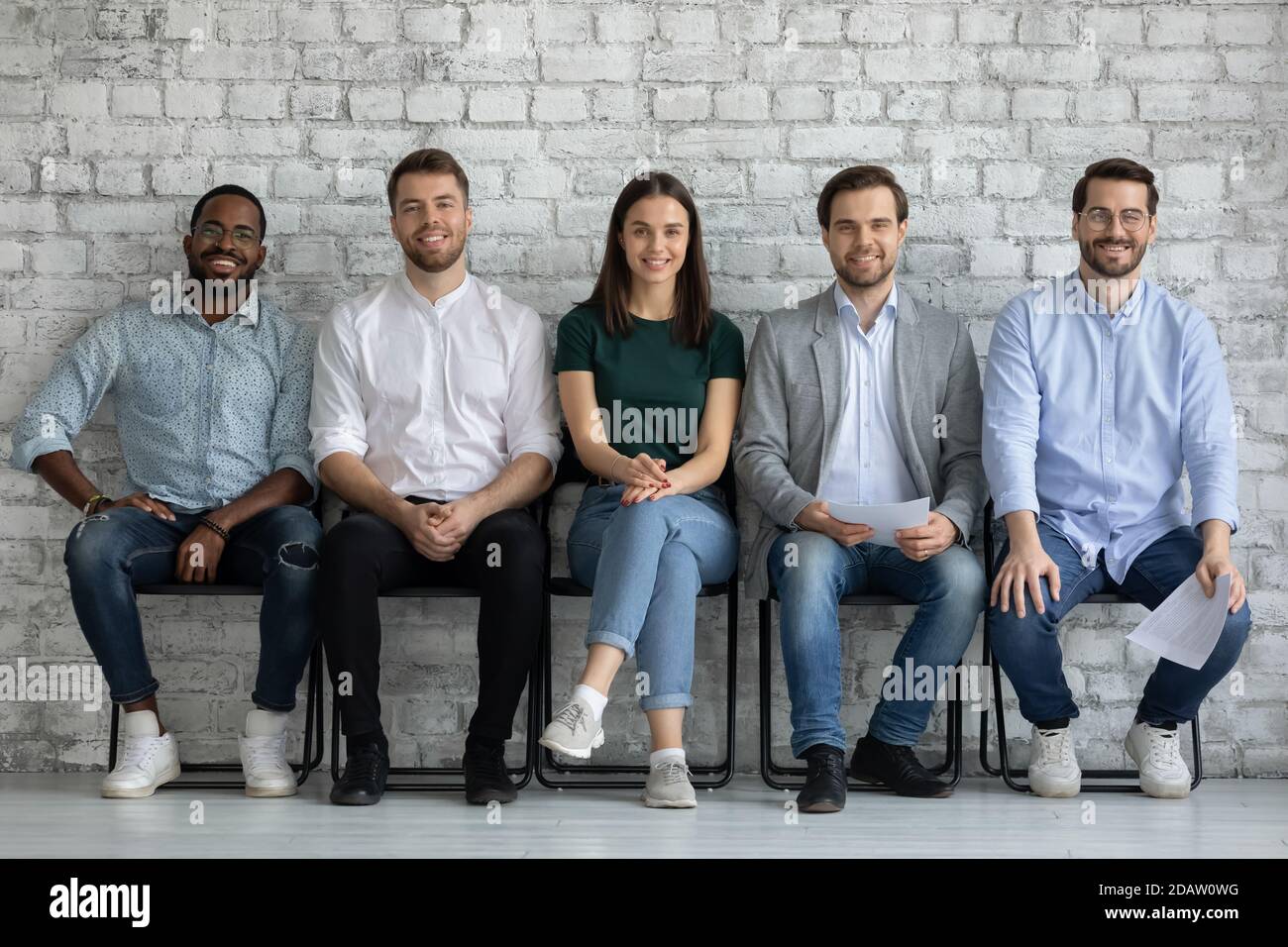 Clients multiethniques heureux assis dans la rangée satisfaits du service reçu Banque D'Images