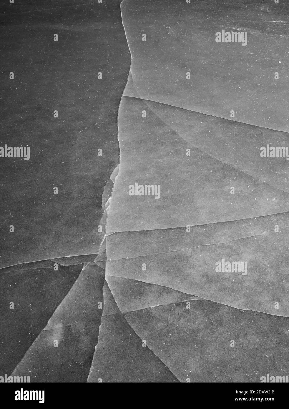 Gros plan de la glace grise fissurée Banque D'Images