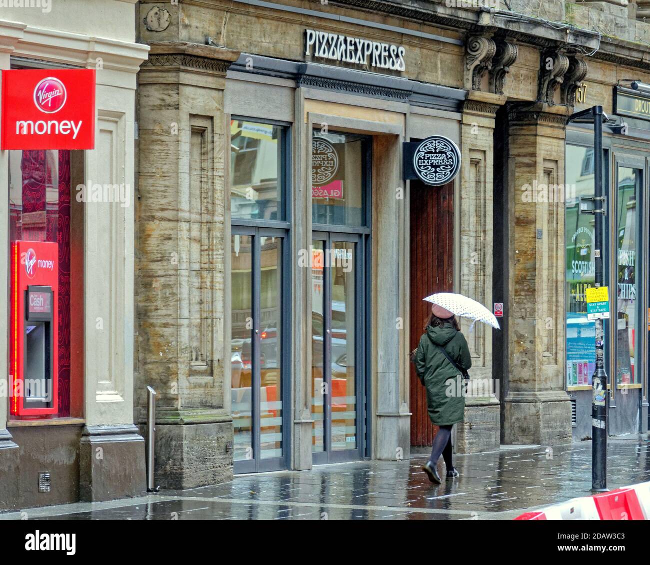 Glasgow, Écosse, Royaume-Uni. 15tht novembre, 2020: Royaume-Uni Météo: Humide de départ comme la pluie est l'ordre du jour avec des parasols pour assortir les masques de visage avec un fond de dystopie pure comme le niveau 3 exerce la misère sur les locaux. Crédit : Gerard Ferry/Alay Live News Banque D'Images