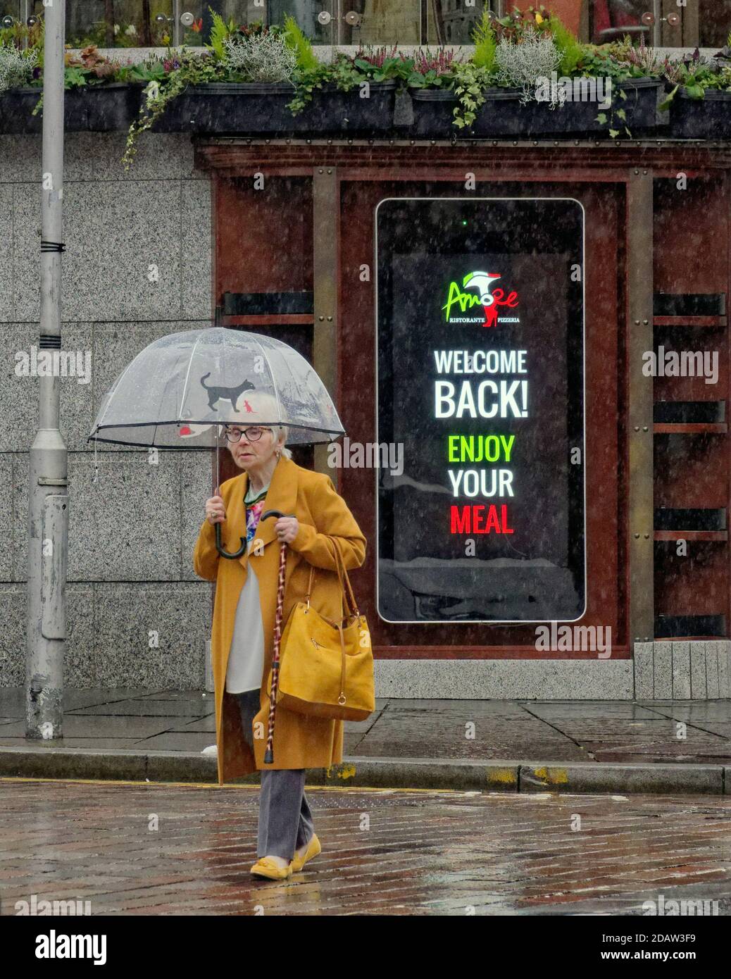 Glasgow, Écosse, Royaume-Uni. 15tht novembre, 2020: Royaume-Uni Météo: Humide de départ comme la pluie est l'ordre du jour avec des parasols pour assortir les masques de visage avec un fond de dystopie pure comme le niveau 3 exerce la misère sur les locaux. Crédit : Gerard Ferry/Alay Live News Banque D'Images