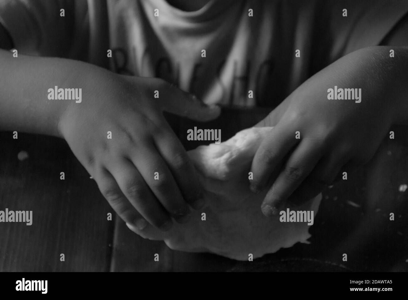 les mains de bébé pétrissent la pizza Banque D'Images