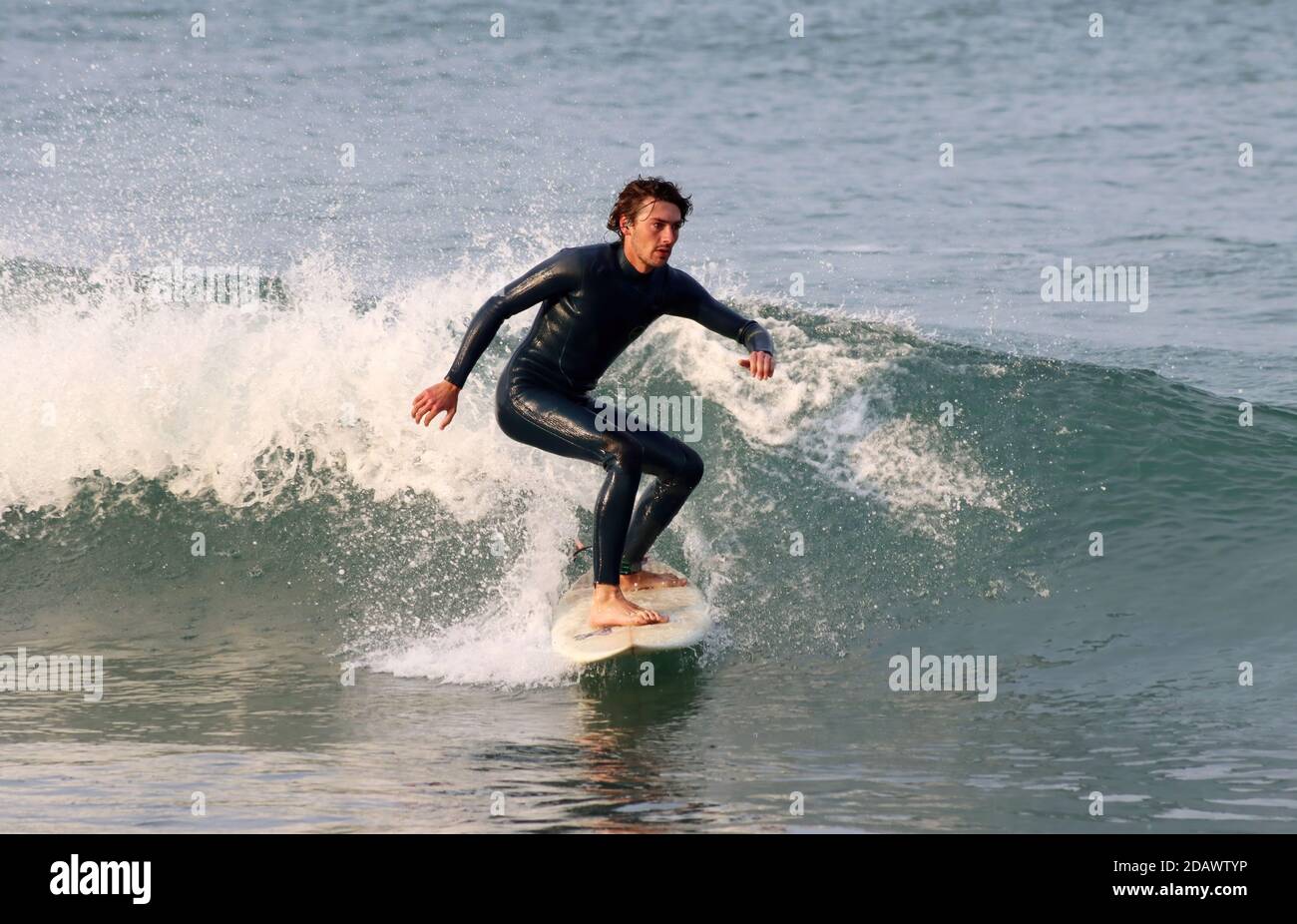 Surfeur de planche dans une combinaison noire attrapant la vague Banque D'Images