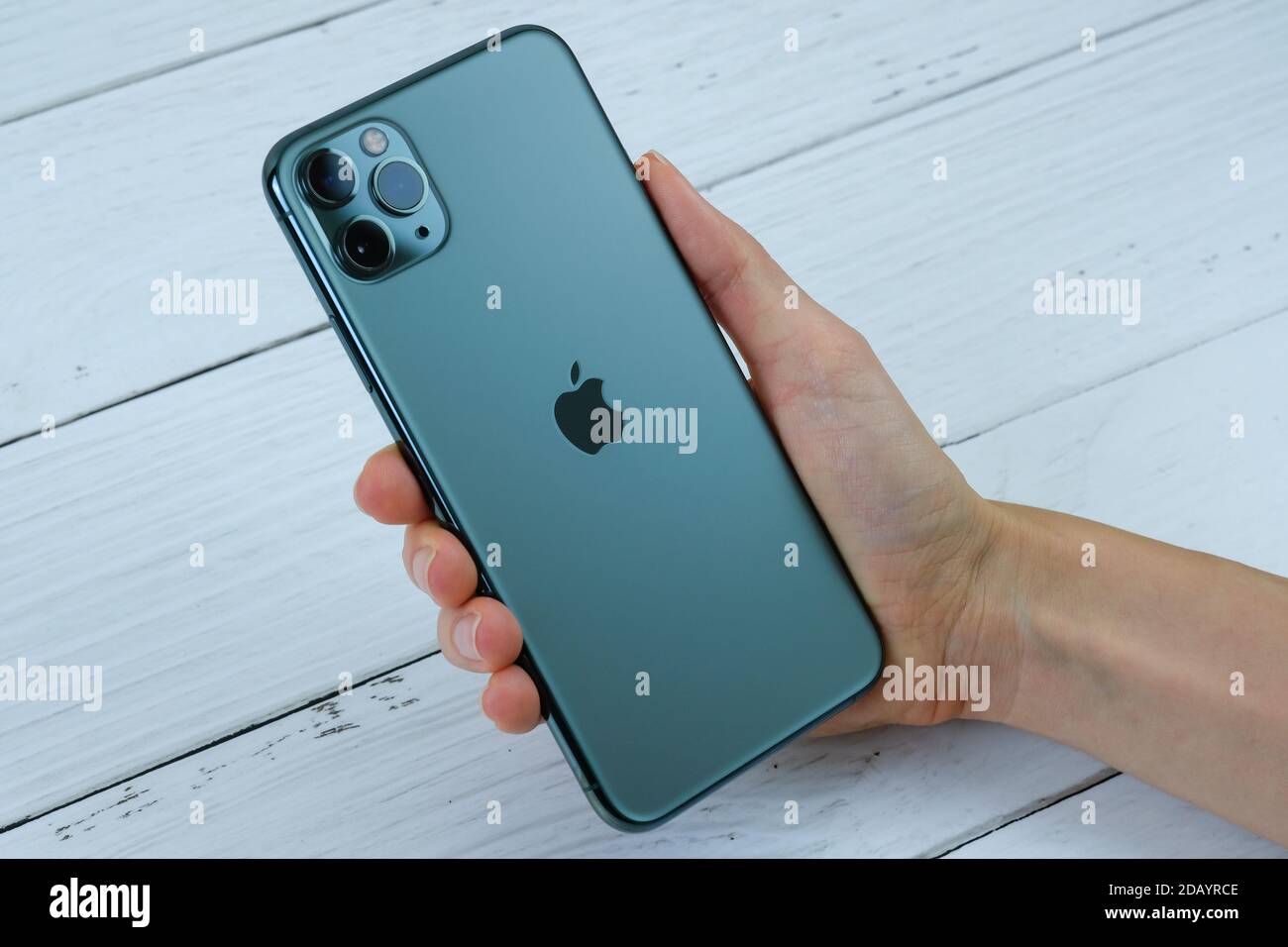 IPhone 11 Pro Max en vert minuit dans la main d'un client. Banque D'Images