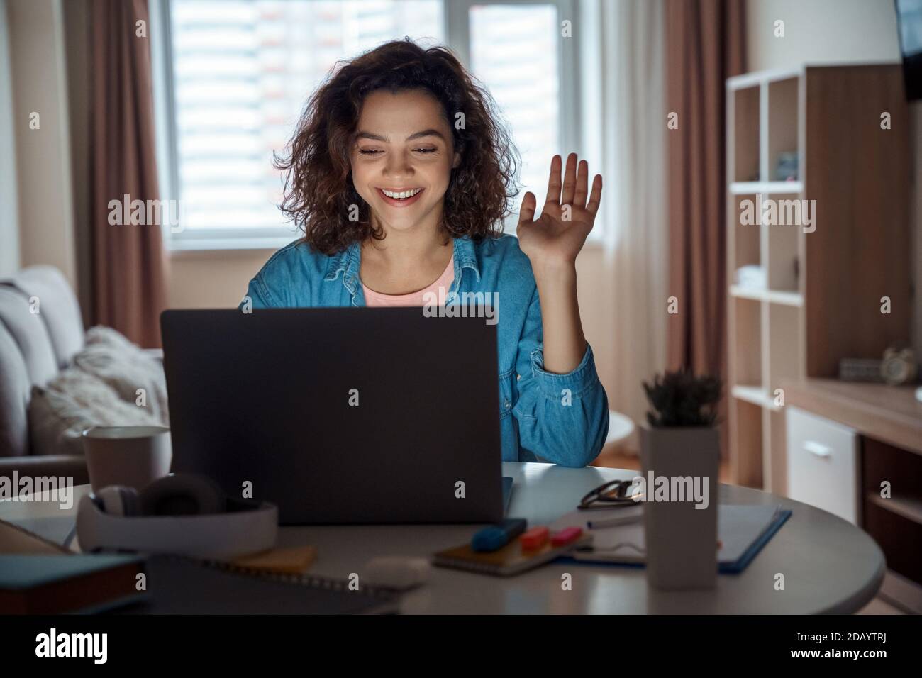 Jeune femme latine heureuse enseignante travaillant en ligne sur ordinateur portable à la maison. Banque D'Images