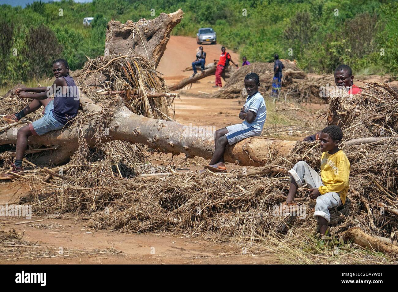 Raymond Muzungu (chemise noire), Christopher Matiza (chemise rouge) et d'autres du village de Nyarowa s'assoient sur un pont détruit par le Cyclone Idai. Banque D'Images