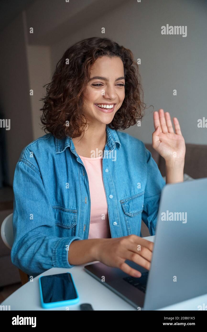 Jeune femme latine heureuse enseignante travaillant en ligne sur ordinateur portable à la maison. Banque D'Images