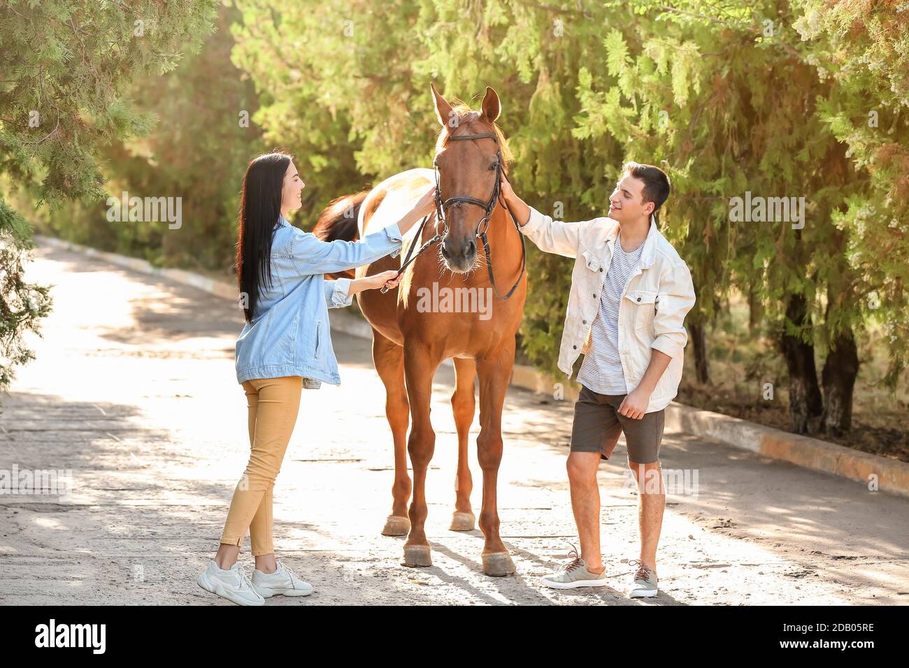 Jeune couple avec mignon cheval en plein air Banque D'Images