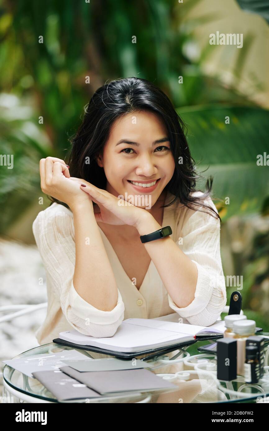 Jolie jeune femme assise à table Banque D'Images