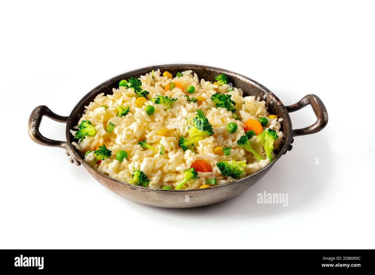 Riz vegan sauté avec légumes dans une casserole, sur fond blanc. Brocoli, pois verts et carottes dans un plat maison sain, recette facile Banque D'Images