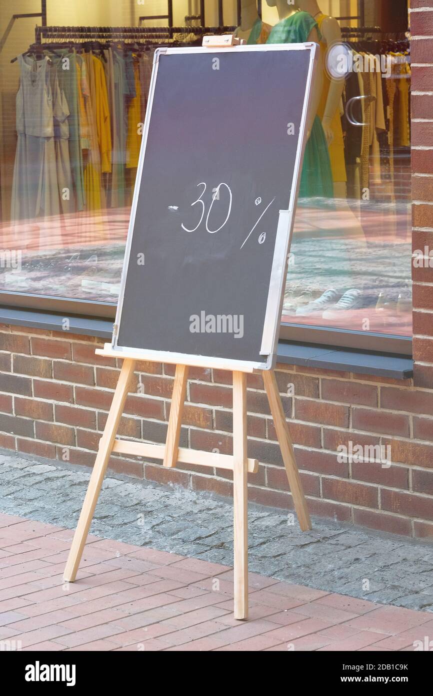 Tableau noir avec une réduction sur la rue, panneau. Tableau blanc avec texte dans une ville européenne. Banque D'Images