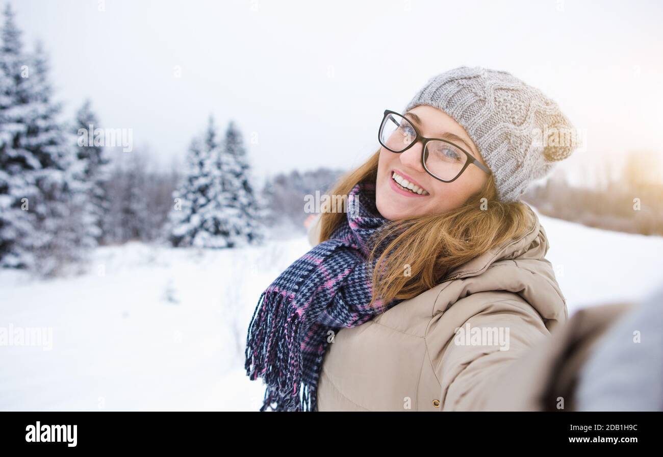 Une jeune femme prend le selfie sur fond d'hiver enneigé forêt Banque D'Images
