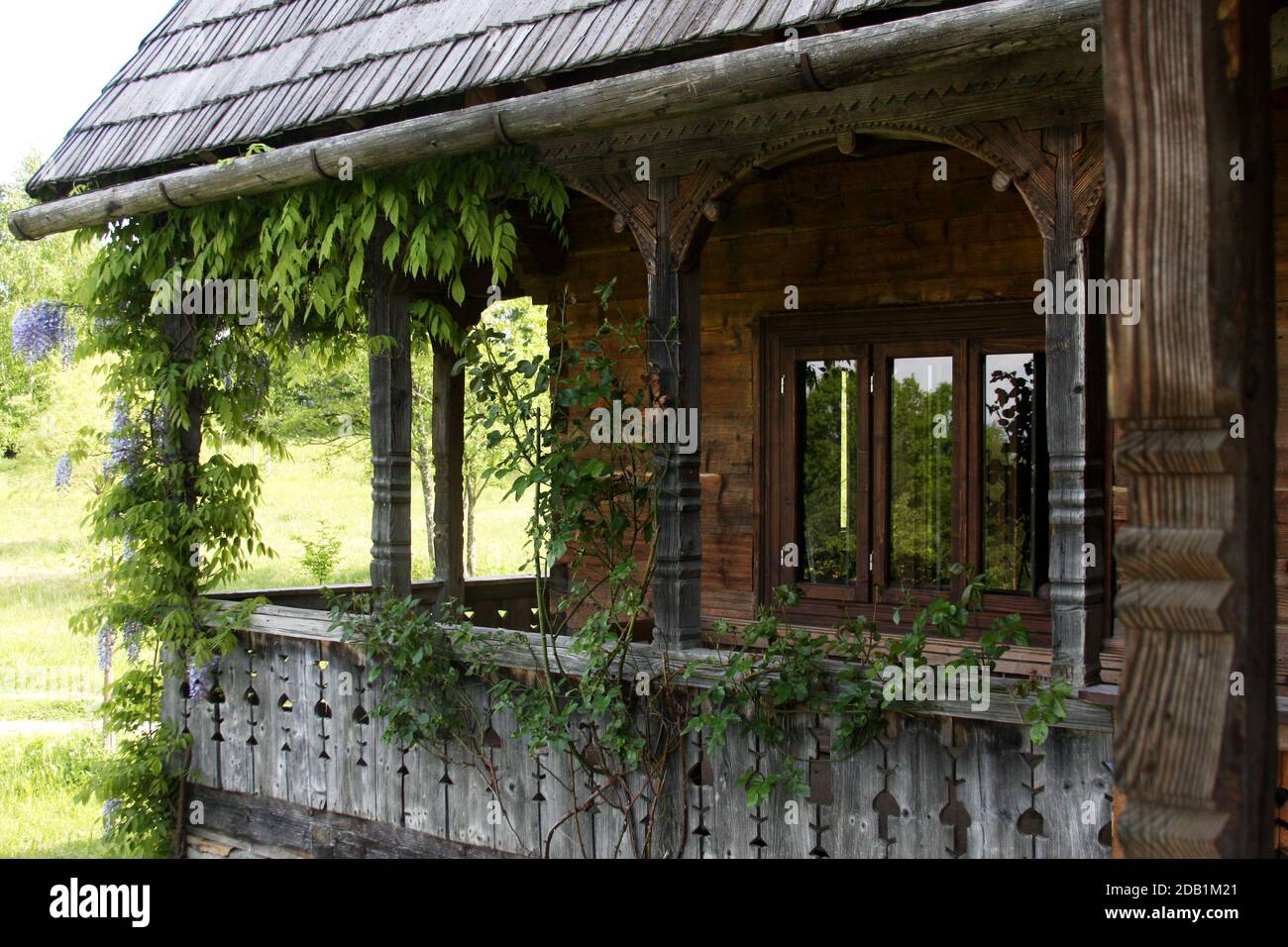 Maramures, Roumanie. Maison traditionnelle en bois avec une belle véranda enveloppante. Banque D'Images