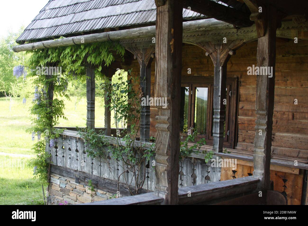 Maramures, Roumanie. Maison traditionnelle en bois avec une belle véranda enveloppante. Banque D'Images