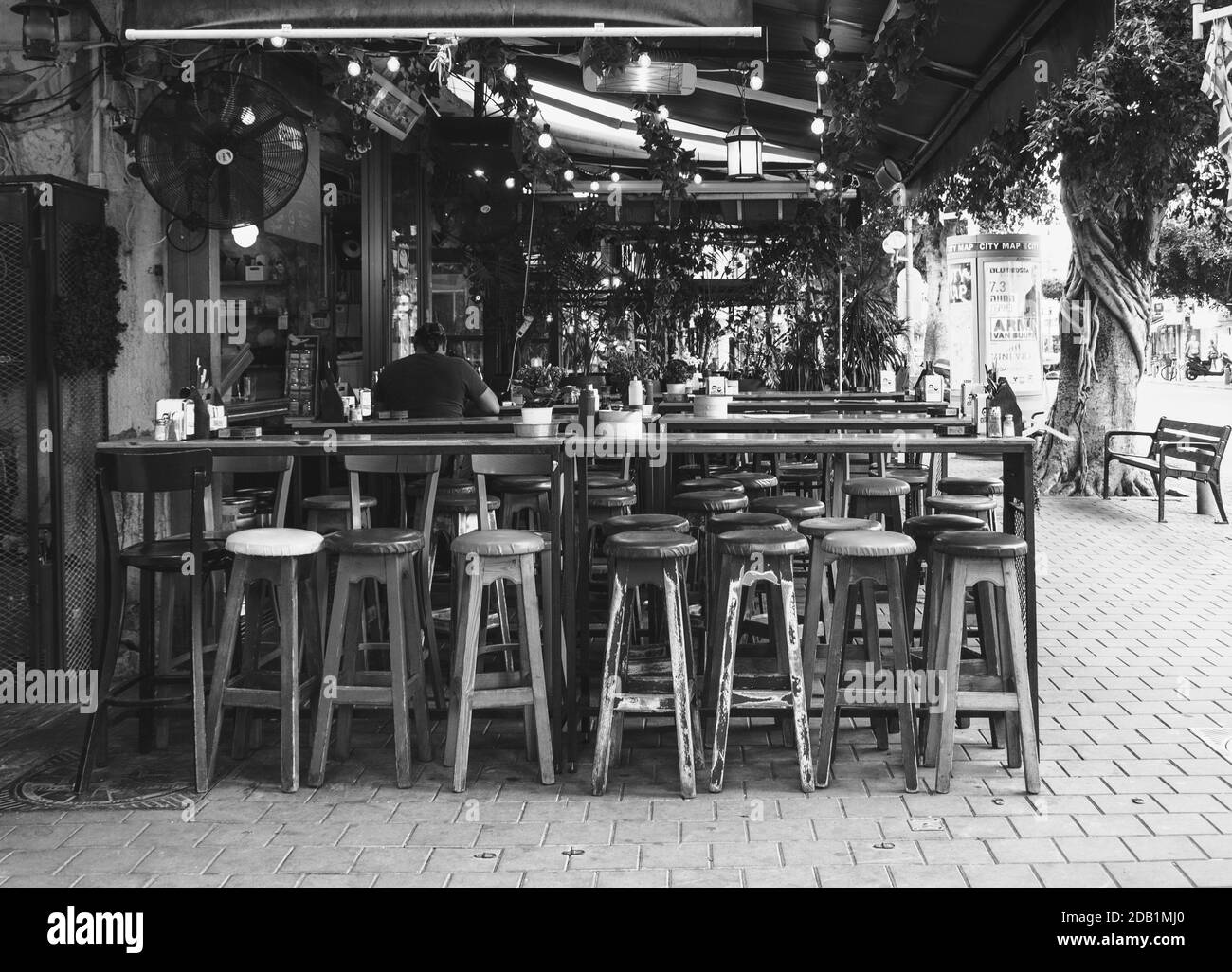 TEL AVIV-JAFFA, ISRAËL - 6 MARS 2019 : terrasse extérieure vide d'un bar-restaurant typique de la rue Dizengoff Street. Photo noir et blanc. Banque D'Images