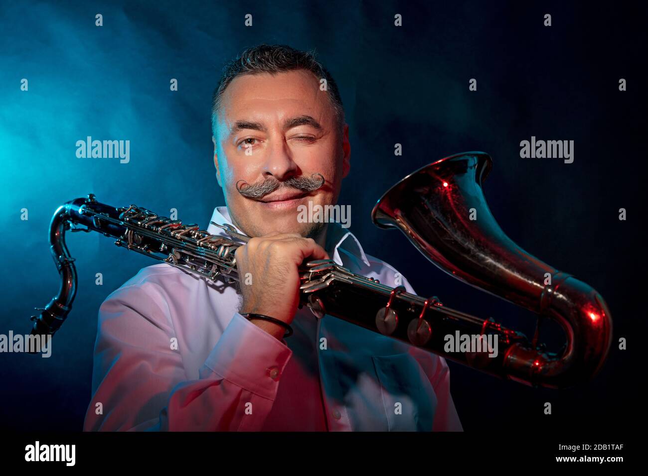 Homme avec un saxophone dans ses mains, photo dans le studio arrière-plan sombre. Photo de haute qualité Banque D'Images