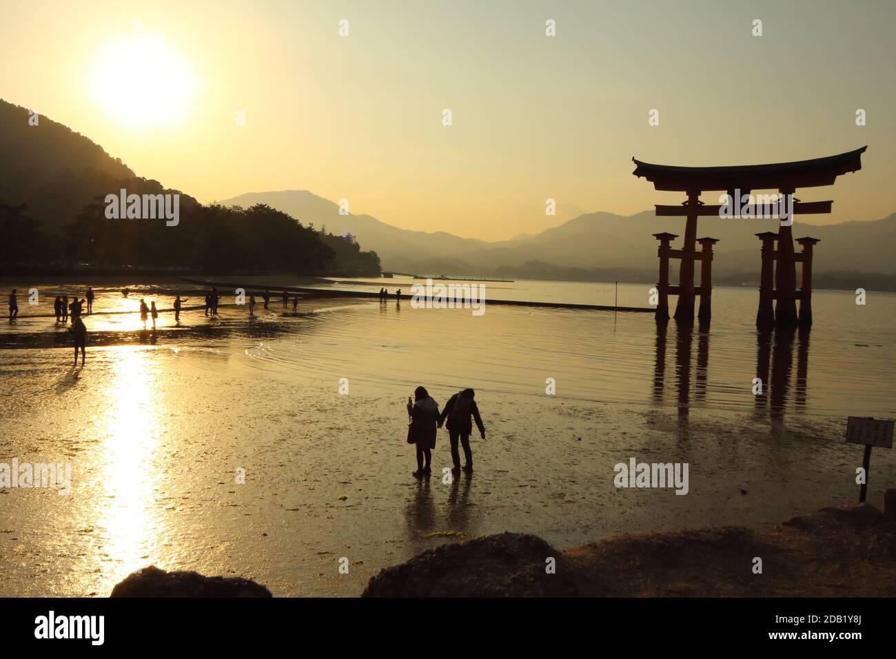 Japon Vermilion Torii Itsukushima-Jinja sur Miyajima . Scène de coucher de soleil avec silhouette de couple. Calme spirituel relaxant paisible romantique île de la paix. Banque D'Images