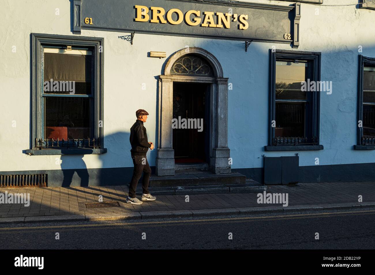 Homme à chapeau plat, sur la rue John à l'extérieur de la maison publique Brogans à Kilkenny, comté de Kilkenny, Irlande Banque D'Images