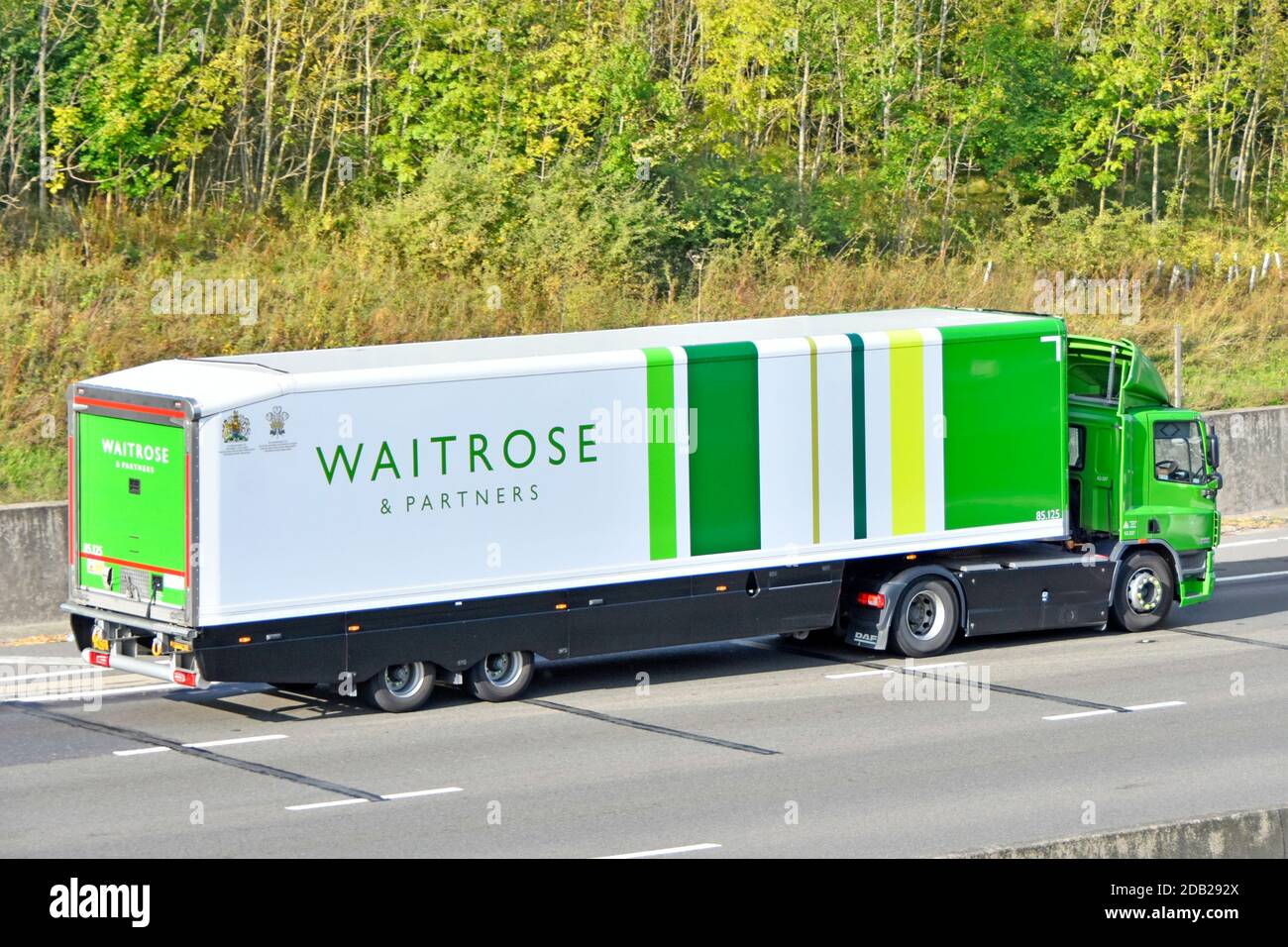 Vue latérale et arrière de Waitrose Retail business supermarché alimentation Livraison par chaîne de camions et de remorques avec Royal Prenez la route britannique de l'Angleterre Banque D'Images