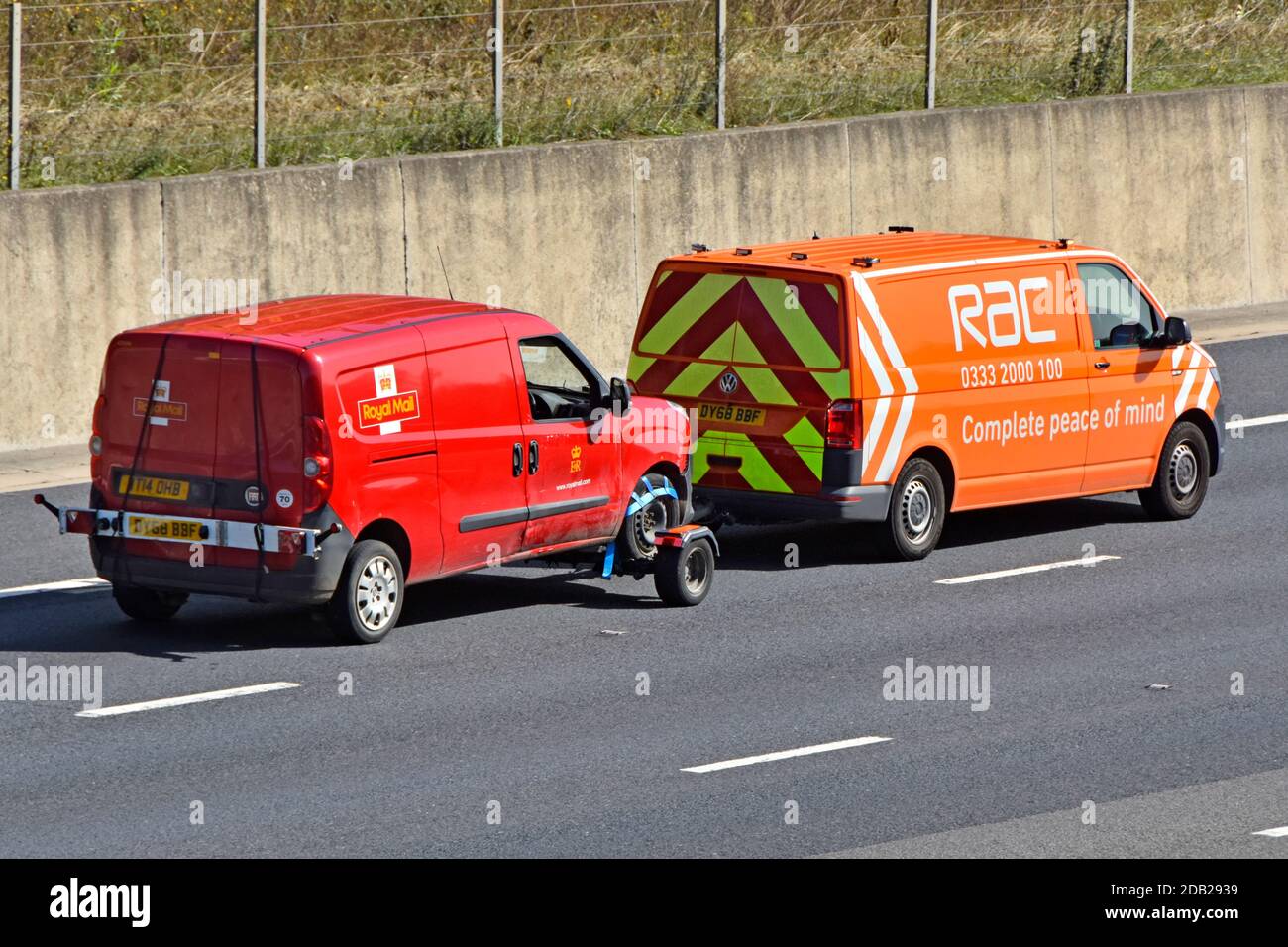 Vue latérale et vue arrière de la poste Red Royal Mail La camionnette de livraison est remorquée par la camionnette Volkswagen avec publicité Pour la tranquillité d'esprit RAC sur l'autoroute britannique Banque D'Images