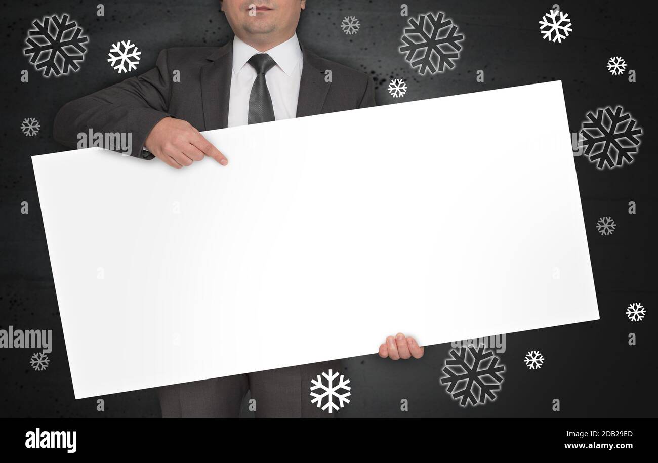 L'affiche du concept de flocons de neige est tenue par un homme d'affaires. Banque D'Images
