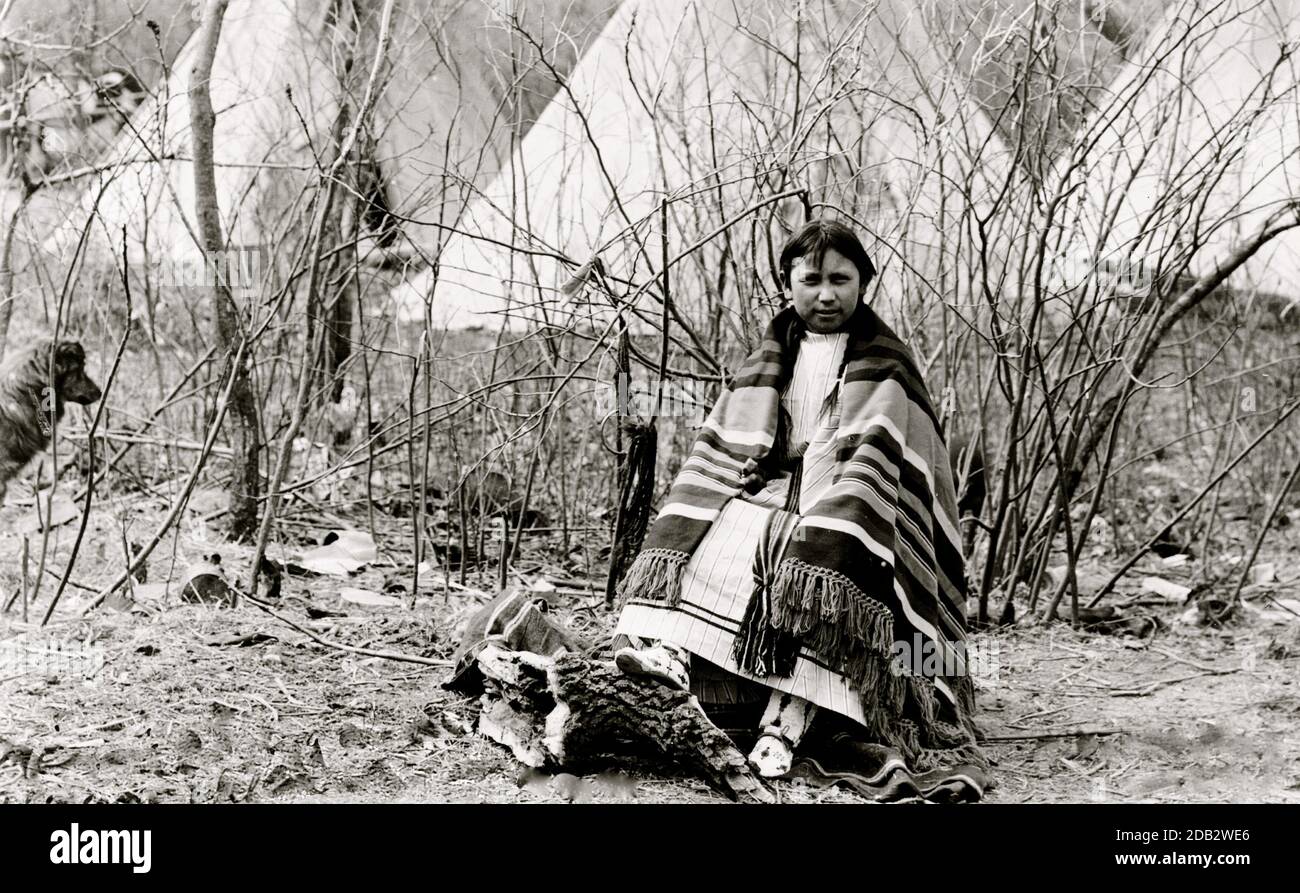 Portrait en longueur de la fille de l'école, assise, portant des vêtements traditionnels. Banque D'Images